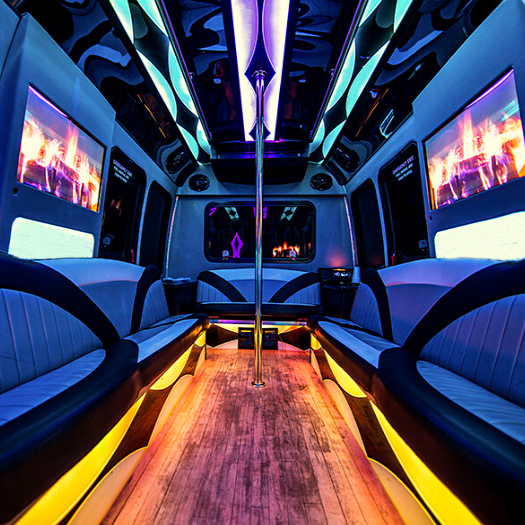 Dance poles and leather seating in a party bus
